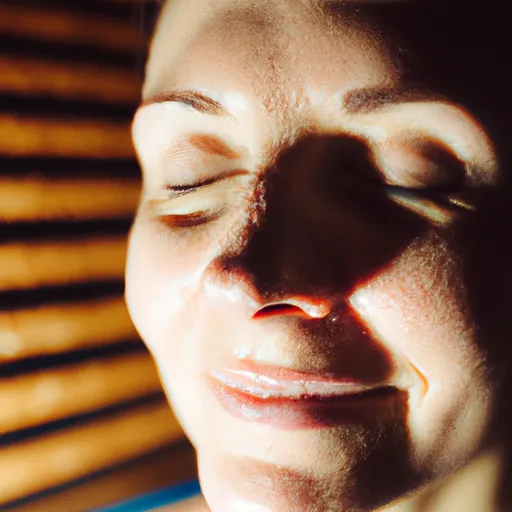 

A close-up of a person's face, eyes closed and a peaceful smile on their lips, as they relax in a sauna.